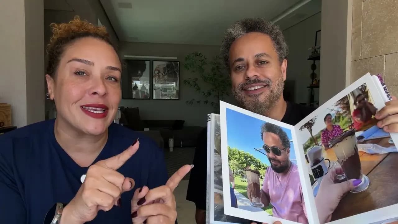 Os fundadores do Álbum Imperdível segurando um álbum impresso aberto