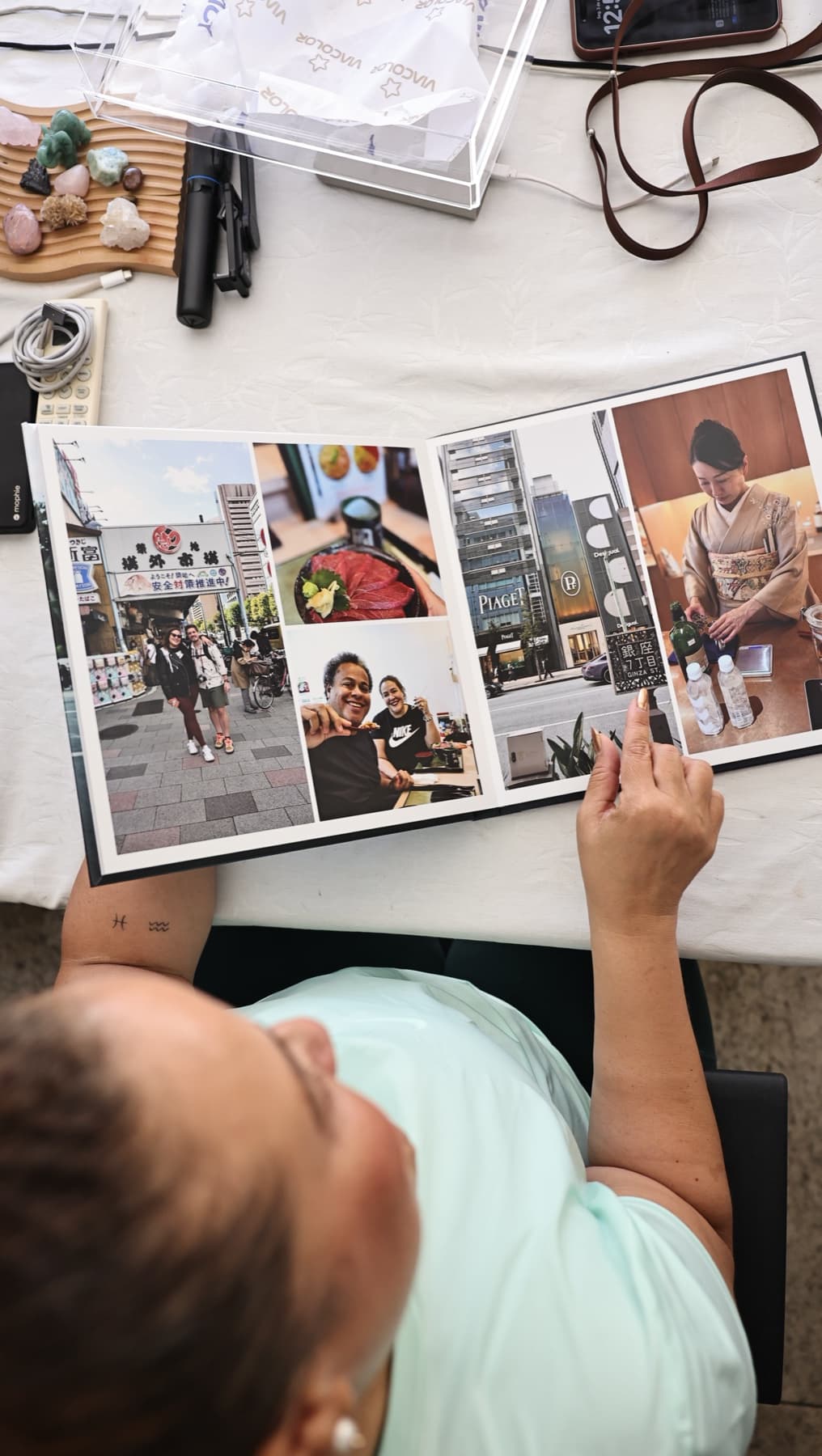 Pessoa folheando um álbum de viagem com fotografias do Japão