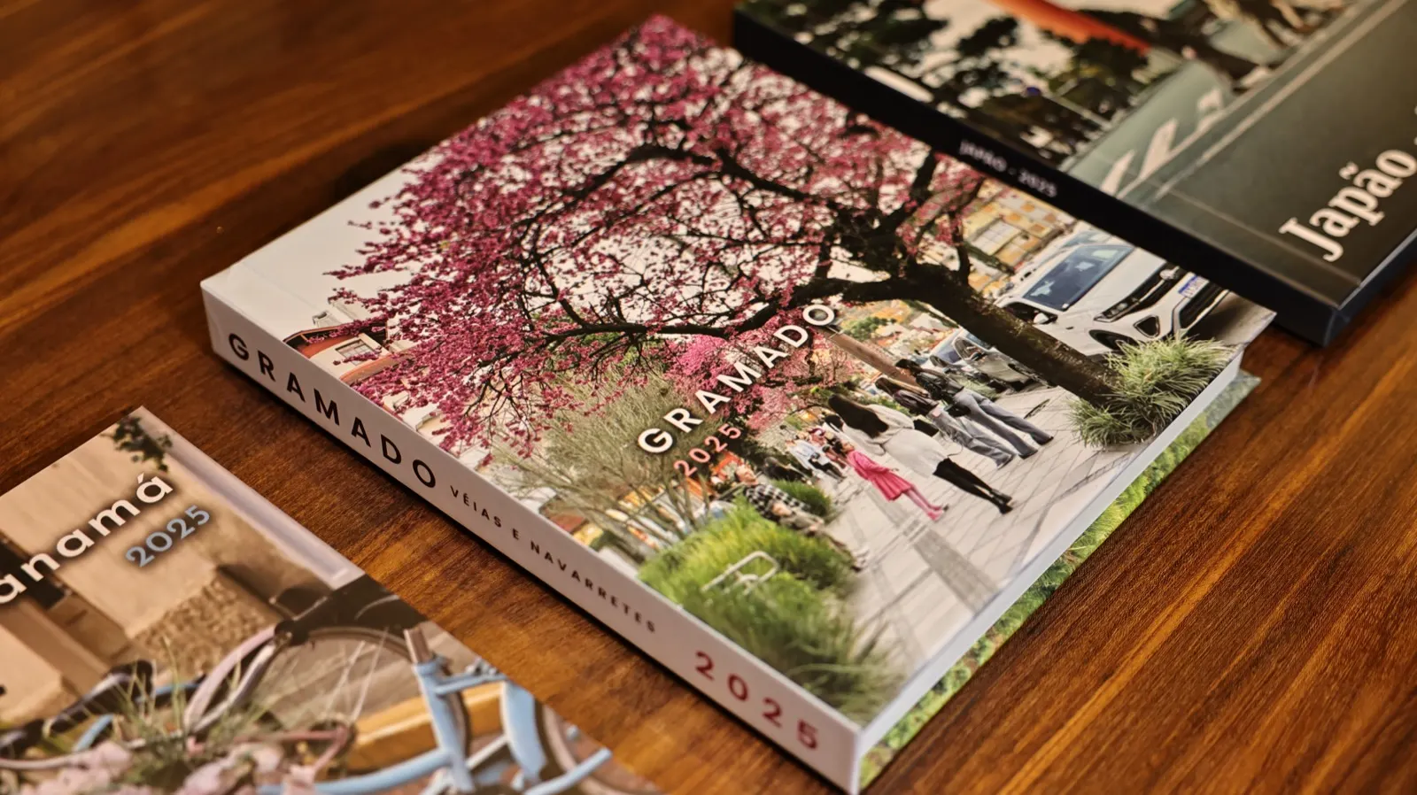 Fotolivros de Gramado e do Japão sobre a mesa, cada um com uma foto da viagem na capa